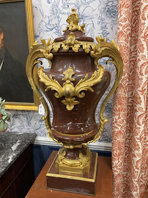Lot 158 - A pair of French Empire style rouge marble lidded urns