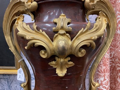 Lot 158 - A pair of French Empire style rouge marble lidded urns