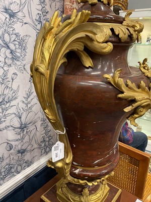 Lot 158 - A pair of French Empire style rouge marble lidded urns