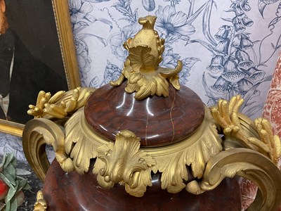 Lot 158 - A pair of French Empire style rouge marble lidded urns