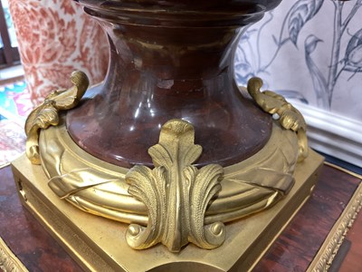 Lot 158 - A pair of French Empire style rouge marble lidded urns
