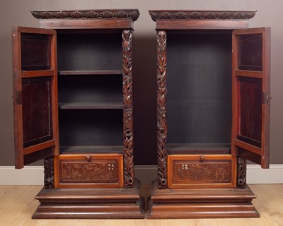 Lot 70 - A pair of 20th-century Chinese hardwood panel inset pedestal cupboards
