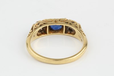 Lot 199 - A sapphire and diamond half hoop ring, centred...