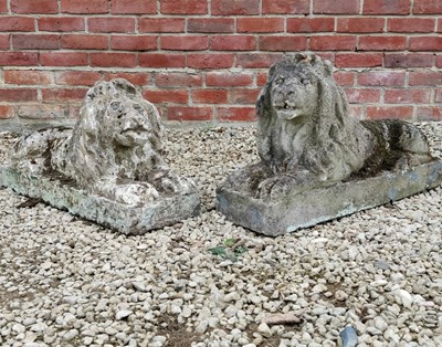 Lot 572 - Two similar cast reconstituted stone recumbent lions with glass eyes