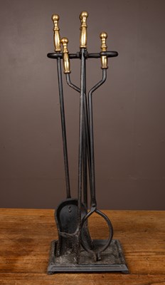 Lot 425 - A set of fire irons with brass handles in a stand