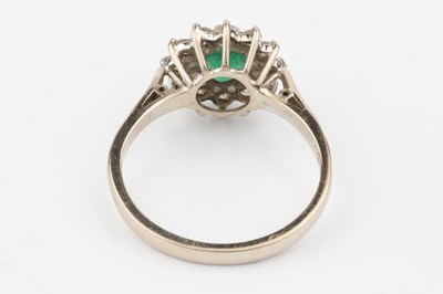 Lot 52 - An emerald and diamond cluster ring, the...