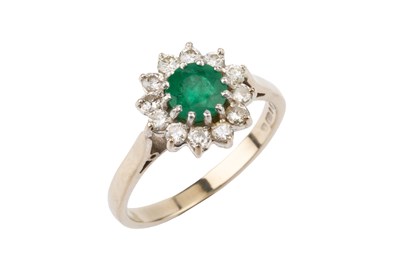 Lot 52 - An emerald and diamond cluster ring, the...