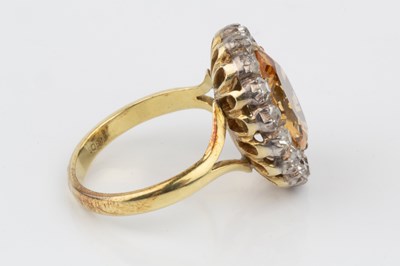 Lot 9 - A topaz and diamond cluster ring, the oval...