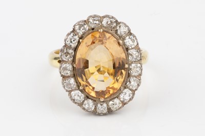 Lot 9 - A topaz and diamond cluster ring, the oval...