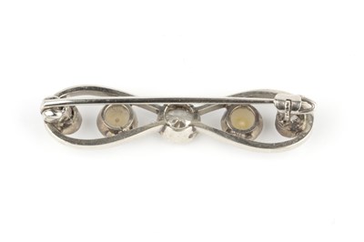 Lot 23 - A diamond and half pearl bow brooch, centred...