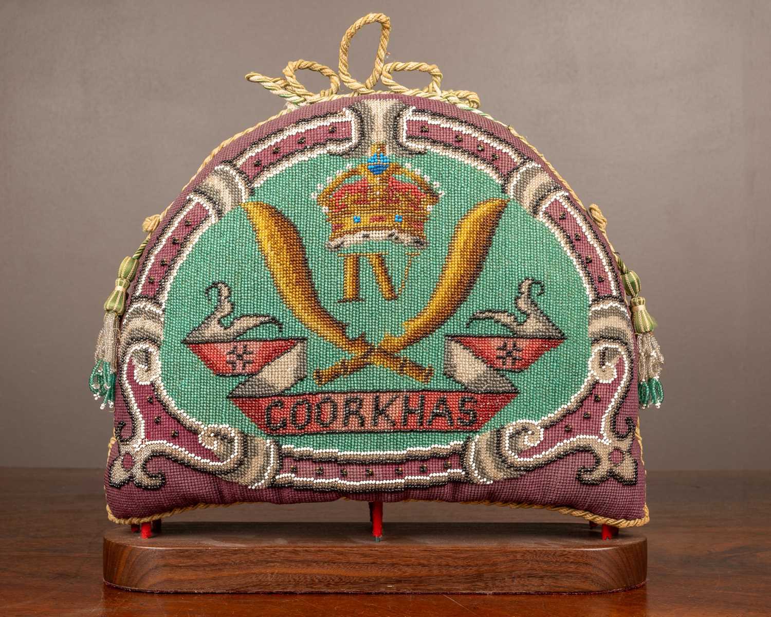 Lot 64 - An old beadwork tea cosy of military interest
