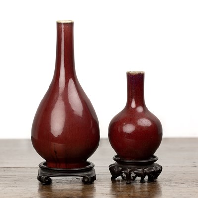 Lot 117 - Two sang de boeuf vases on wooden stands...