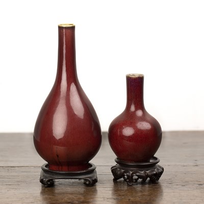 Lot 117 - Two sang de boeuf vases on wooden stands...