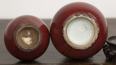 Lot 117 - Two sang de boeuf vases on wooden stands...