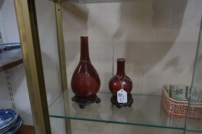 Lot 117 - Two sang de boeuf vases on wooden stands...