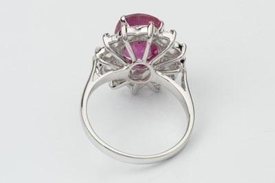 Lot 191 - A ruby and diamond cluster ring, the oval...