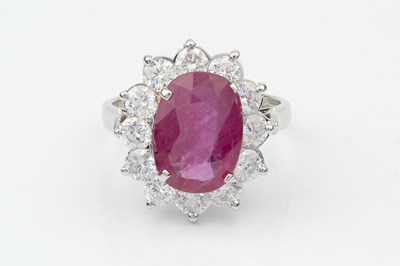 Lot 191 - A ruby and diamond cluster ring, the oval...
