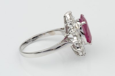 Lot 191 - A ruby and diamond cluster ring, the oval...