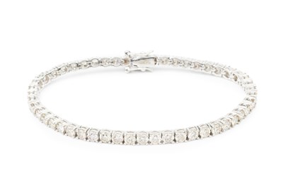 Lot 242 - A diamond line bracelet, set in platinum with...