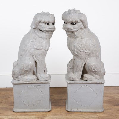Lot 84 - Two large off-white glazed temple dogs in the...