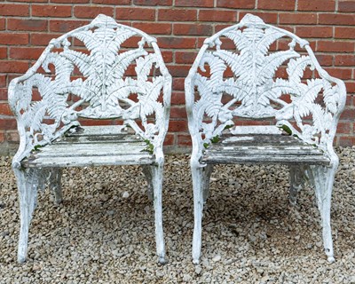 Lot 1336 - A pair of cast fern patterned garden chairs.