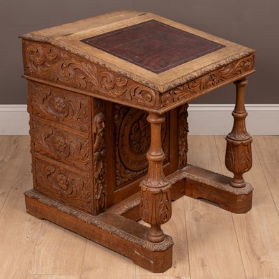 Lot 469 - An ornately carved Victorian oak Davenport