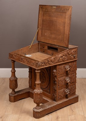 Lot 469 - An ornately carved Victorian oak Davenport