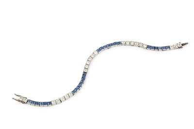 Lot 313 - A diamond and sapphire line bracelet, having...