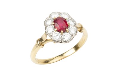 Lot 263 - A ruby and diamond cluster ring, the oval cut...