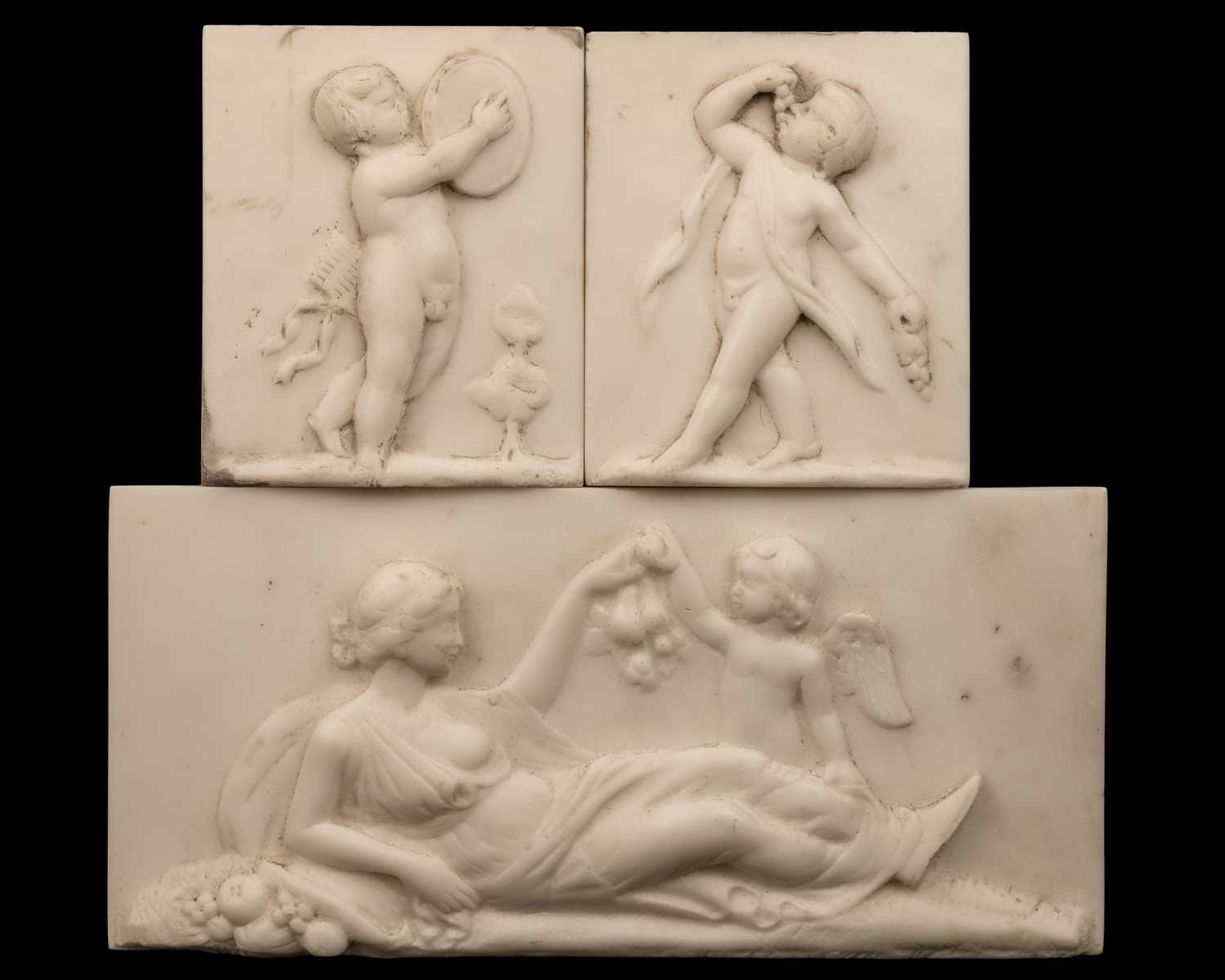 Lot 1231 - A marble tablet of Venus and Cupid together with a pair of marble plaques of putti