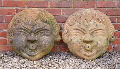 Lot 1191 - A pair of moulded terracotta masks for wall hanging