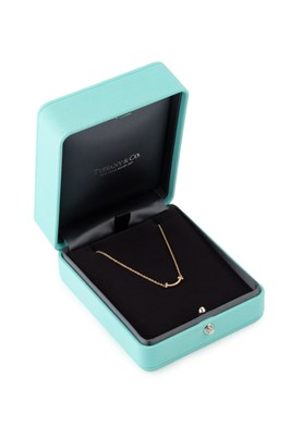Lot An 18ct gold and diamond T-Smile necklace by...