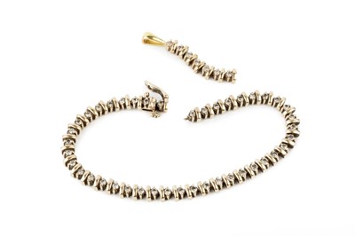 Lot 63 - An 18k gold and diamond line bracelet, set...