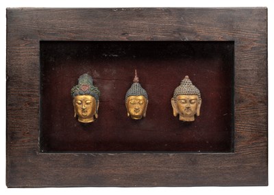 Lot 1112 - A cased set of three terracotta Buddha heads