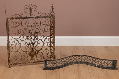 Lot 1189 - A wrought iron fire screen and Georgian brass fender