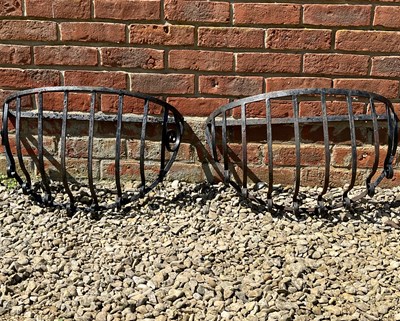 Lot 1255 - A pair of black painted wrought iron wall baskets