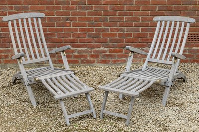 Lot 1320 - A pair of teak steamer style reclining garden chairs