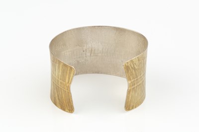 Lot 232 - A silver cuff bangle, of slightly waisted form,...
