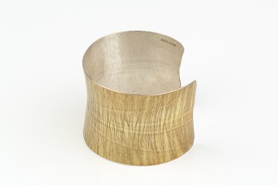 Lot 232 - A silver cuff bangle, of slightly waisted form,...