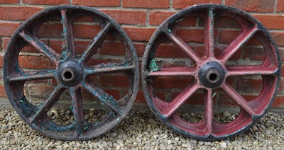 Lot 1344 - A pair of antique cast iron vehicle or farm implement wheels