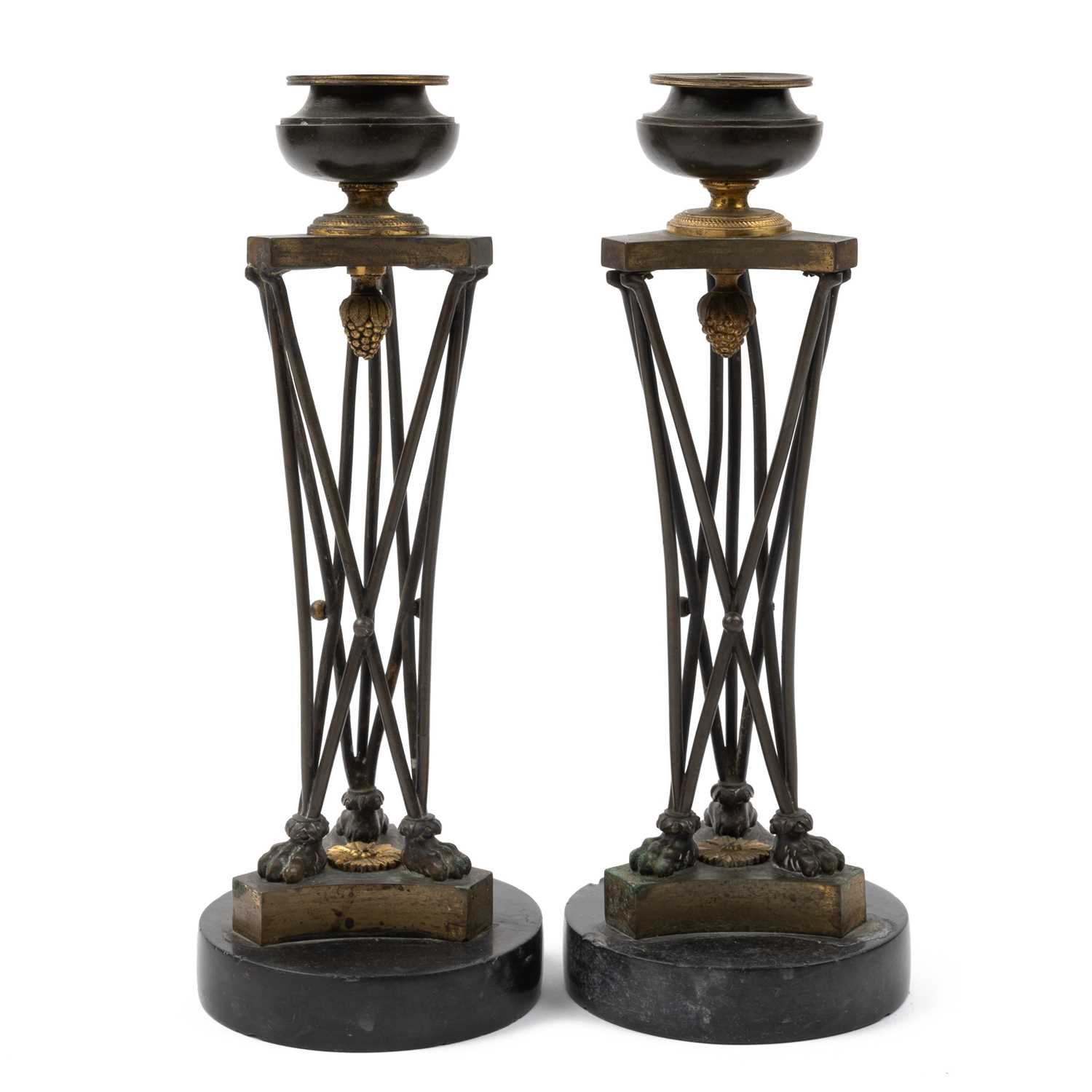 Lot 3 - A pair of regency bronze and ormolu candlesticks in the manner of Thomas Hope