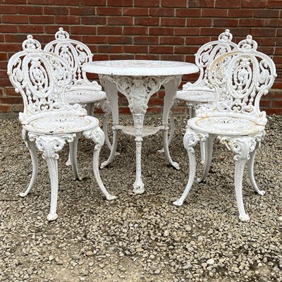 Lot 1417 - A cast iron garden table and four garden chairs