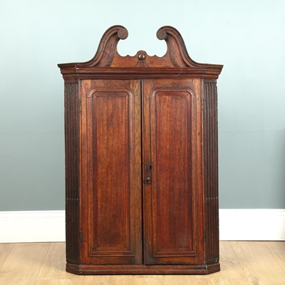 Lot 123 - A George III oak corner cupboard