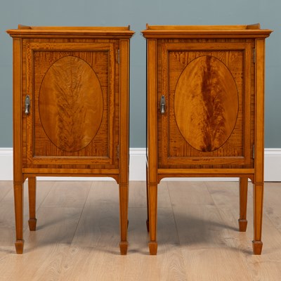 Lot 317 - A pair of early 20th century satinwood bedside cabinets by Warings