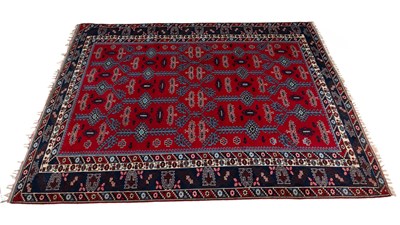 Lot 1252 - A mid to late 20th century red and blue ground carpet