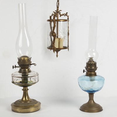 Lot 252 - A brass hanging lantern together with two glass and brass oil lamps