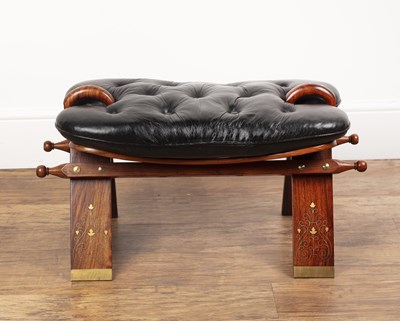 Lot 56 - Camel saddle stool 20th Century, with black...