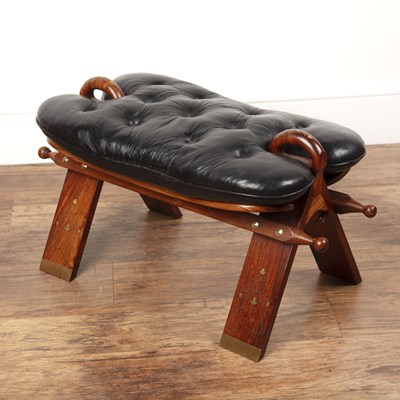 Lot 56 - Camel saddle stool 20th Century, with black...