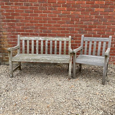 Lot 1371 - A teak garden bench together with a similar armchairs