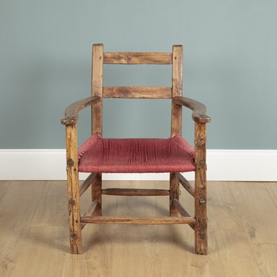 Lot 605 - A rustic elmwood armchair